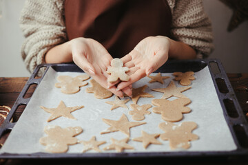Woman baking christmas gingerbread cookies at home