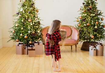 Two little sisters near the Christmas tree.