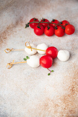 mozzarella and cherry tomato canapé caprese salad buffet meal snack on the table copy space food background rustic. top view keto or paleo diet