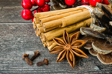 Closeup of Ceylon Cinnamon Sticks, Star Anise and Whole Cloves on Weathered Wood