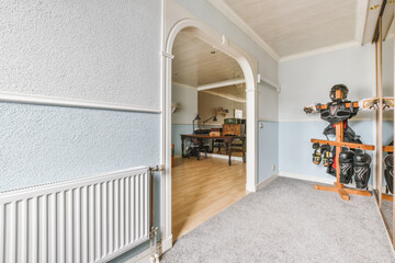 A small narrow room with a large arch leading in turn to another room