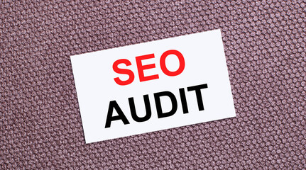 On a brown background, a white rectangular card with the text SEO AUDIT