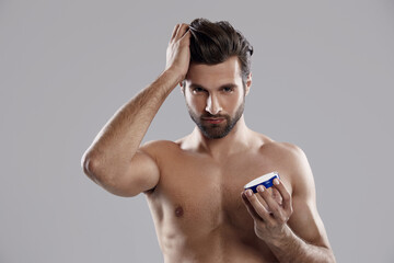 Man holding hair gel and touching his ideal hair