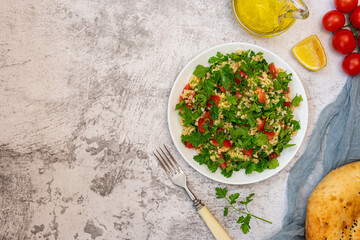 Middle Eastern cuisine. Vegetarian salad with bulgur, vegetables. Fresh bright arabic salad. Tabbouleh salad