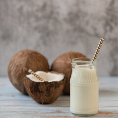 Coconut milk and coconuts on a light background