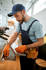 Repairman fixing professional coffee machine in cafe
