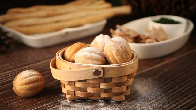 Woman hand take homemade fresh cookies in a shape of nuts with condensed milk