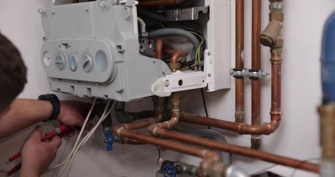 HVAC Worker Repairing Gas Heater. Gas boiler service, central heating system inspection.