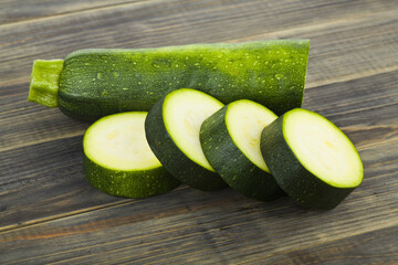 Green zucchini on wooden background.