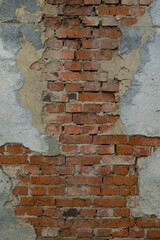 Texture of an old brick wall. Brick wall background with peeling plaster. Brick wall with fallen plaster.