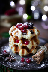 
Waffles with blackberries and currants. Christmas sweets. Table with desserts and Christmas decorations. Still life with sweets