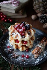 
Waffles with blackberries and currants. Christmas sweets. Table with desserts and Christmas decorations. Still life with sweets