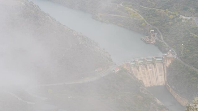 Mountain and Douro river with spanish Saucelle Dam at foggy cloudy weather. Border between Portugal and Spain. National Parks. View from portuguese Penedo Durao lookout.