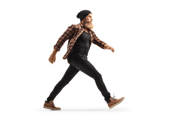 Full length profile shot of a bearded guy making a big step