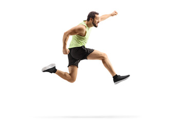 Full length profile shot of a young fit man in sportswear jumping and gesturing happiness