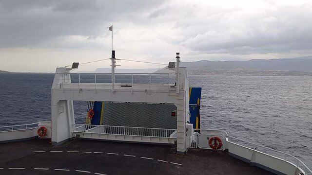 Veduta di prua del traghetto sullo stretto di Messina, che si avvicina alla costa calabrese