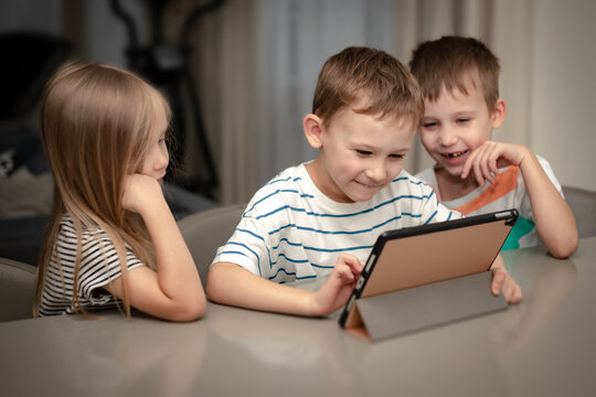 children play computer games on ipad and laugh
