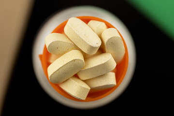 heap of pills close-up. vitamin dietary supplements on a black background. immune prevention care concept