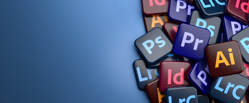 Logos of the major parts of the Creative Cloud Apps Suite (Illustrator, Photoshop, InDesign, Lightroom Classic, Premiere Pro) on a heap on a table. Copy space. Web banner format.