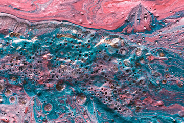 Fluid Art. Embossed mixing, craters and drips of pink and turquoise paint. Marble effect background or texture