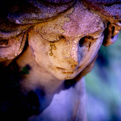 Beautiful guardian angel with tears in his eyes. Fragment of an ancient statue