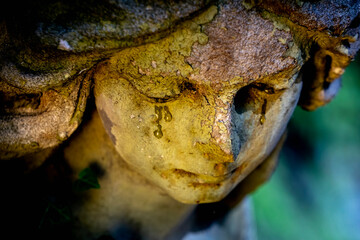 Sad ngel with tears in the eyes. Fragment of an antique statue. Death concept.