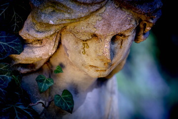 Close up sad guardian angel. Fragment of an antique statue.