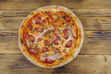 Delicious fresh pizza with sausage, mushrooms and cheese on a wooden table. Top view