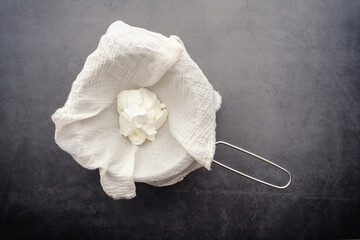 Making Labneh Cheese in a Cheesecloth Lined Strainer: Straining yogurt mixed with lemon juice and...