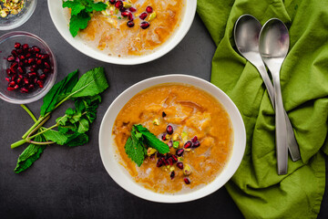 Overhead View of Moroccan Roasted Pumpkin Soup: Roasted pumpkin soup garnished with mint leaves, pomegranate seeds, and chopped pistachios