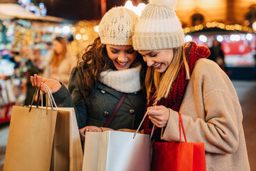 Christmas shopping people concept. Happy young women with shopping bags buying presents - Powered by Adobe