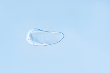 Smeared transparent cream on blue background