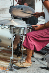 Fototapeta na wymiar side view of a black man playing a percussion instrument in the street, vertical close up picture