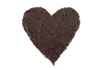 Soil shaped into a heart symbol on white