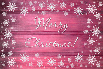 Winter wooden pink rose red magenta nature background with snowflakes around. Texture of painted wood horizontal boards. Merry Christmas card.