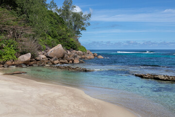Sandy beach with huge rock, stones and hill covered with rainforest in the end. Fossilized corals...