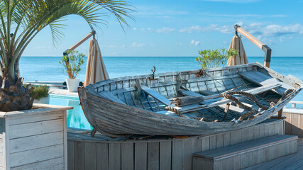 old fishing boat on a wooden pedestal on the sunny embankment of the Russian resort town of Sochi, Russia