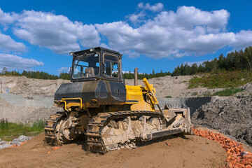 the process of leveling the soil with a modern bulldozer during the construction of a dirt road