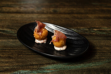 Gourmet Serrano ham croquettes on ceramic palt