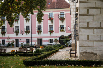 Trebon, South Bohemia, Czech Republic, 9 October 2021: Castle Courtyard, Renaissance chateau with tower and sgraffito mural decorated plaster at facade at sunny day, medieval historical town with park