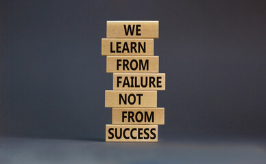 Failure or success symbol. Wooden blocks with words We learn from failure not from success. Beautiful grey background, copy space. Business, learn from failure or success concept.