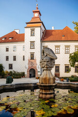 Fototapeta na wymiar Trebon, South Bohemia, Czech Republic, 9 October 2021: Castle Courtyard, Renaissance chateau with sgraffito mural decorated plaster at facade, fountain with sculpture of bird perched on three heads