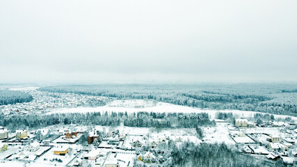Fototapeta na wymiar Aerial view of the winter landscape. White fields of suburban villages