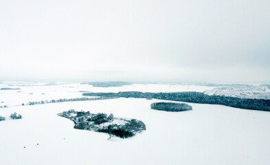 Fototapeta na wymiar Aerial view of the winter landscape. White fields and meadows of nature