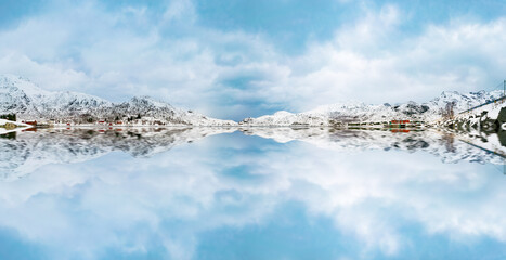 Reflection of mountains in the snow and clouds in the lake