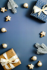 Christmas frame made of gift boxes, fir branches, baubles, star on blue background. Merry Christmas...