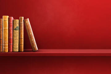 Row of old books on red shelf. Horizontal background