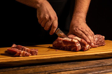 close-up of male hands slicing meat.