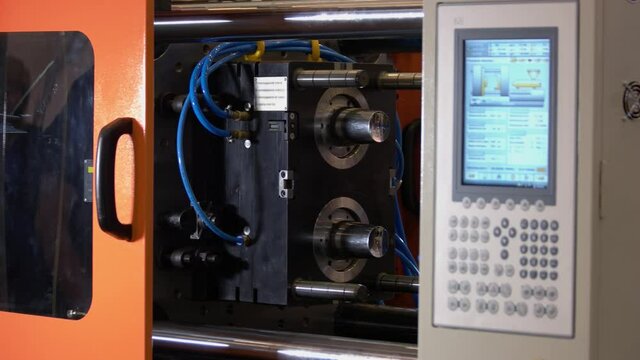 Close-up injection molding machine with control panel.