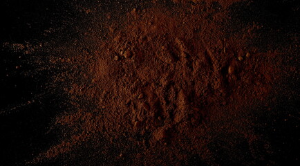 Pile cocoa powder isolated on black background, top view